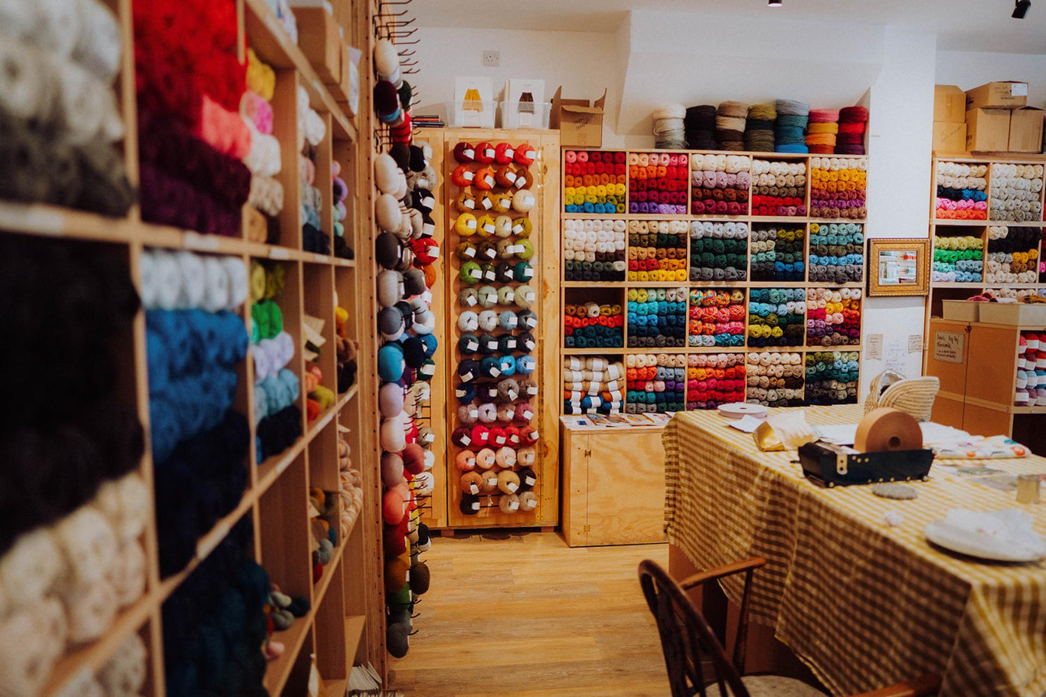 Interior shot of the yarn store, No Frills Knitting in Bristol. The shelves are full of colourful yarns.